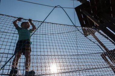 Çocuk ip parkında oynuyor.