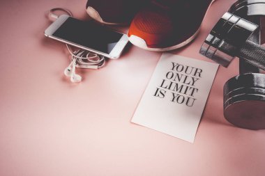 spor ayakkabı, telefon ve pembe bir arka plan üzerinde halter