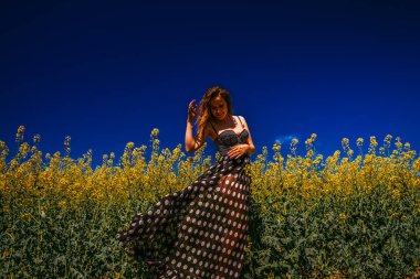 Kolza tarlasında poz veren kadın.