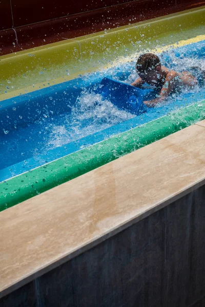 Der Junge fährt eine Rutsche im Wasserpark — Stockfoto