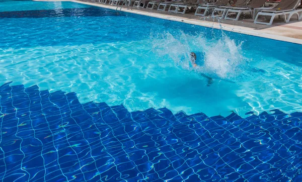 Le garçon saute à la piscine — Photo