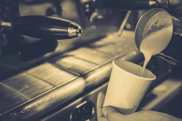 Milch wird in Kaffee gegossen — Stockfoto
