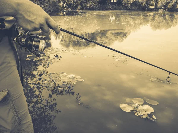 Mano di un pescatore con una canna da pesca — Foto Stock