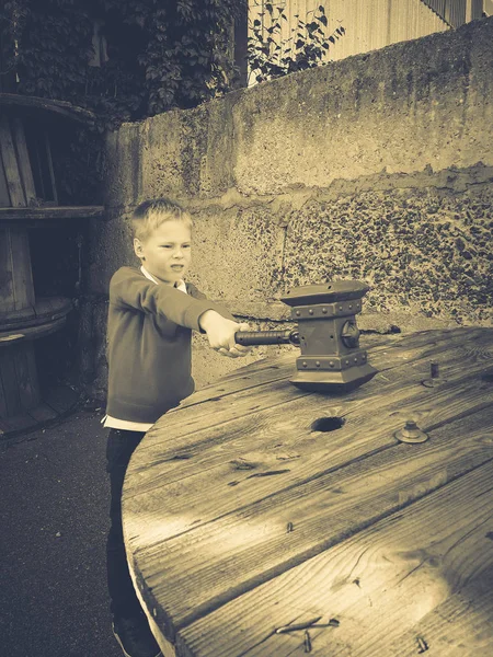 男孩用锤子敲打桌子 — 图库照片
