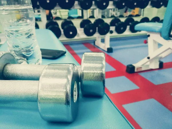 Dumbbells en water in de sportschool — Stockfoto