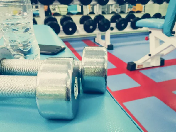 Dumbbells en water in de sportschool — Stockfoto