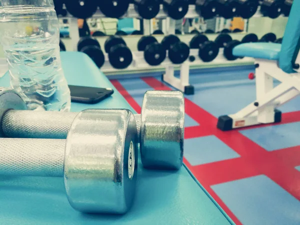 Dumbbells en water in de sportschool — Stockfoto