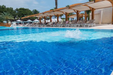 Çocuk havuza atlıyor.