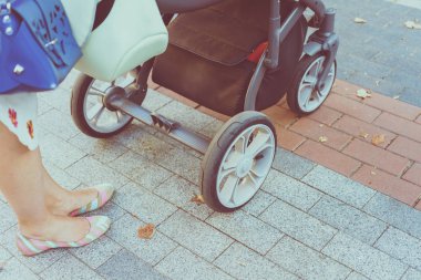 Anne üzerinde bir bebek arabası