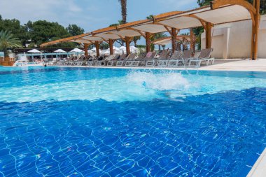 Çocuk havuza atlıyor.