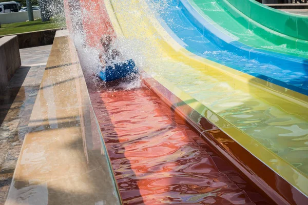 O menino monta um slide no parque aquático — Fotografia de Stock