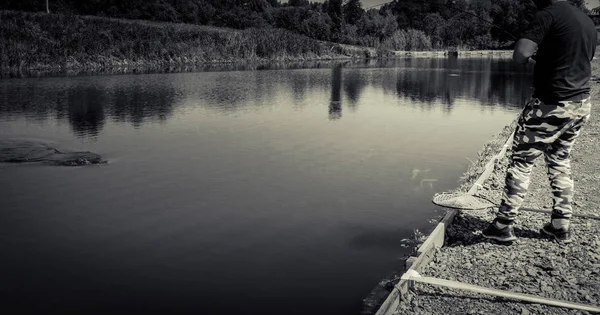 Pescador pegar truta arco-íris do lago — Fotografia de Stock