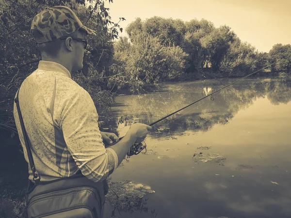 Il pescatore pesca sul lago in estate — Foto Stock