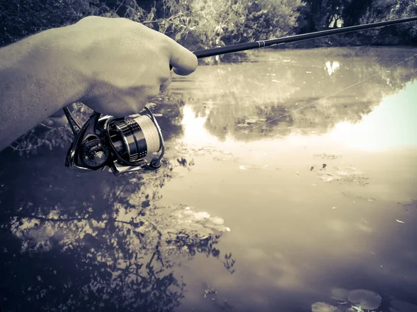 La mano del pescatore sul lago in estate — Foto Stock
