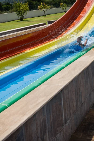 Der Junge fährt eine Rutsche im Wasserpark — Stockfoto