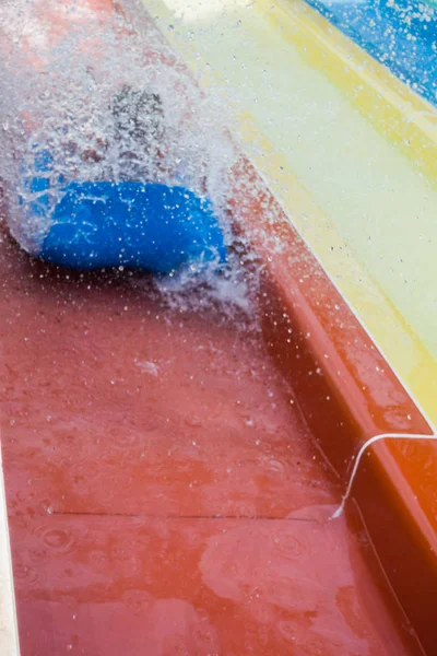 O menino monta um slide no parque aquático — Fotografia de Stock