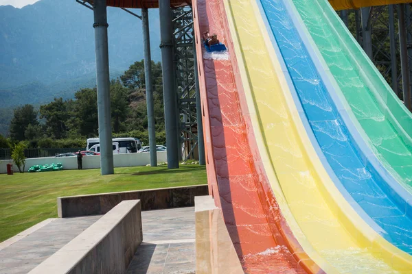 O menino monta um slide no parque aquático — Fotografia de Stock