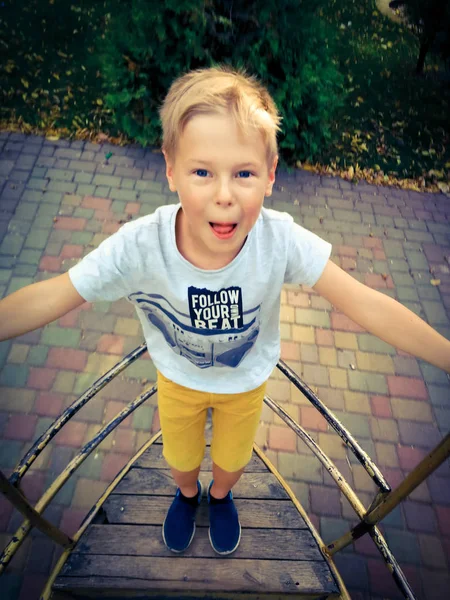 The boy is riding on a swing-boat — Stock Photo, Image