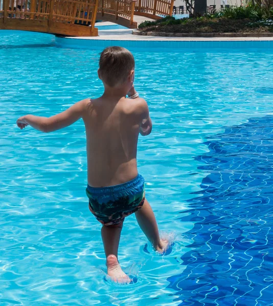 A boy is jumping into the pool — Stock Photo, Image