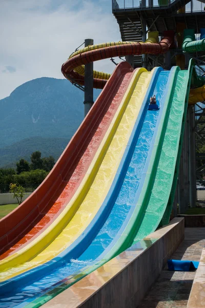 O menino monta um slide no parque aquático — Fotografia de Stock