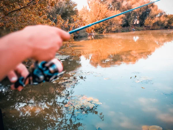 Une main de pêcheur avec une canne à pêche — Photo