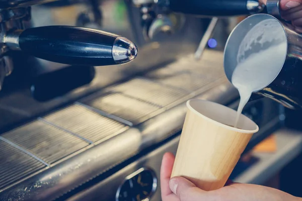 Milch wird in Kaffee gegossen — Stockfoto