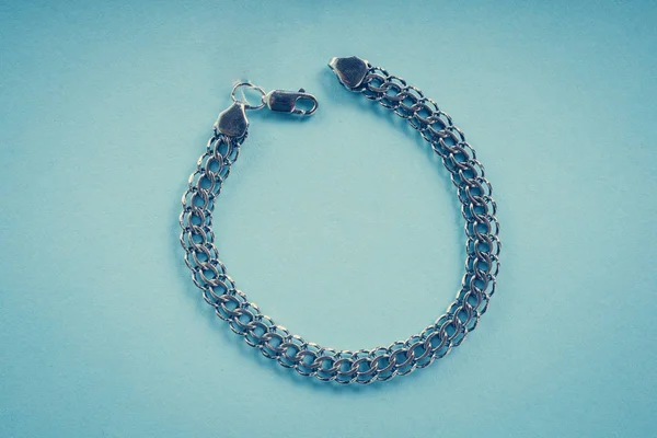 Silberarmband auf blauem Hintergrund — Stockfoto