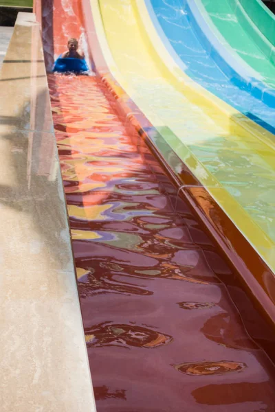 O menino monta um slide no parque aquático — Fotografia de Stock