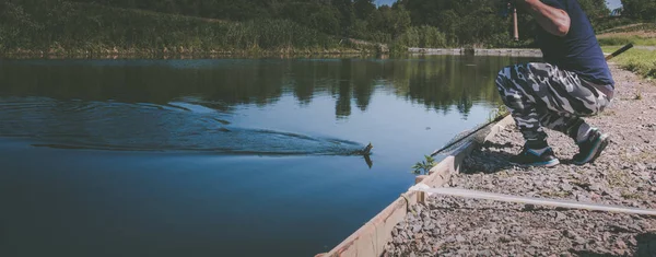 Рыбак ловит радужную форель с озера — стоковое фото