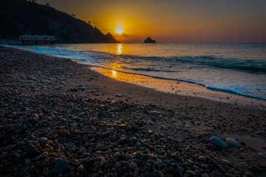 Gündoğumu kumsalda deniz