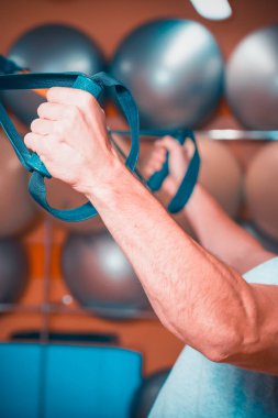 Genç adam bir spor salonunda trx devreye girer