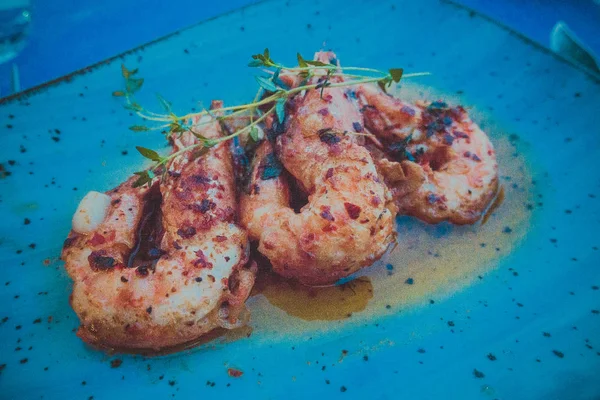 Crevettes grillées sur une assiette bleue — Photo