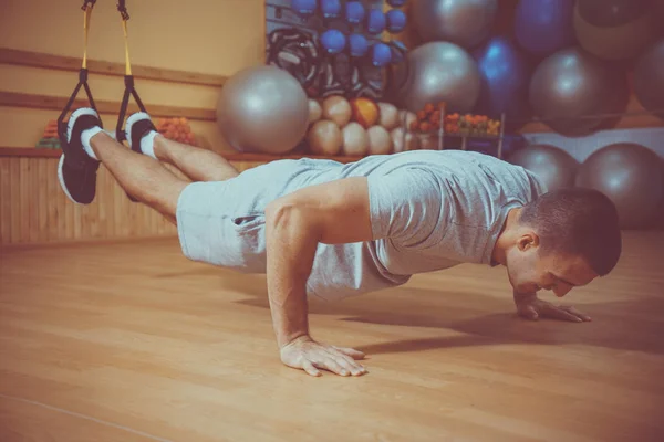 Ung man är engagerad i ett gym i trx — Stockfoto