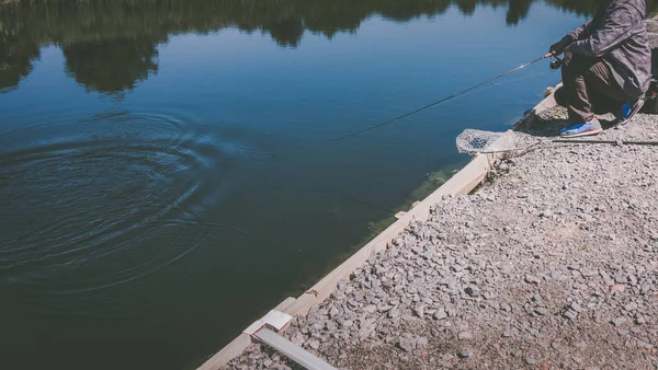 Pescatore cattura trota iridea dal lago — Foto Stock