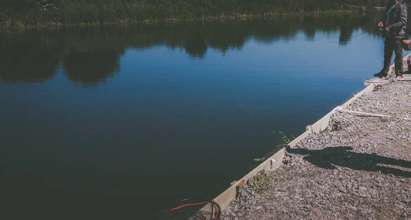 Pescatore cattura trota iridea dal lago — Foto Stock