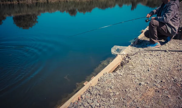 Pescador captura trucha arco iris del lago — Foto de Stock