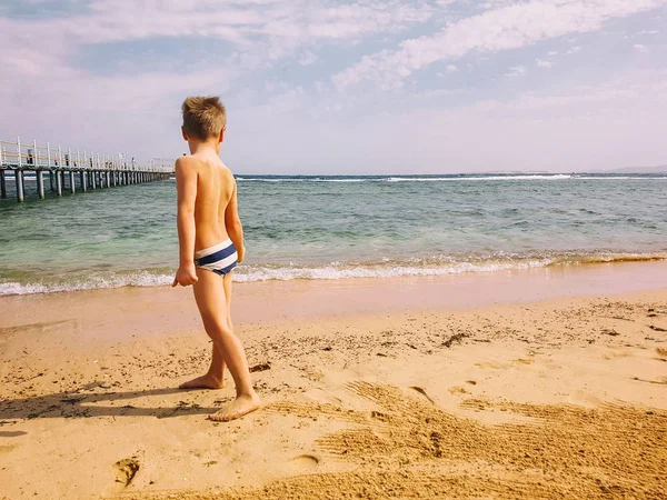 Pieni poika rannalla — kuvapankkivalokuva