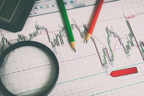 Financiële graphics loep en potloden — Stockfoto