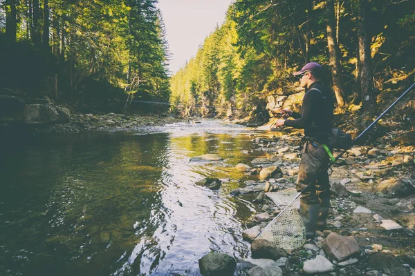 Fisherman on a beautiful mountain river in the forest — Stock Photo, Image