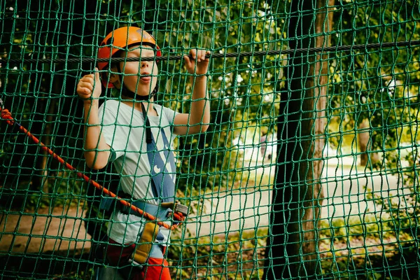 Pojken klättrar en hänge park — Stockfoto