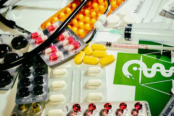 Tabletas, pastillas y un estetoscopio en una mesa —  Fotos de Stock