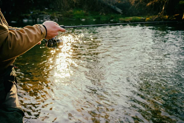 Fischer fängt eine Forelle in einem Gebirgsfluss — Stockfoto