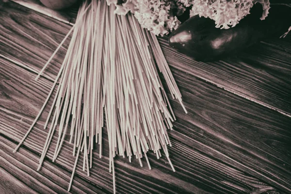 Spaghetti und Gemüse auf einem Holzgrund — Stockfoto