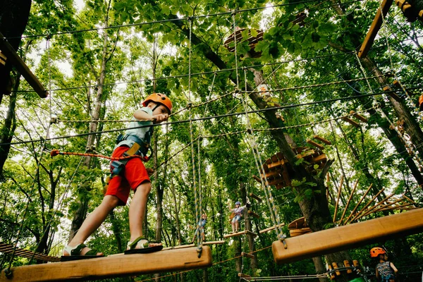Pojken klättrar en hänge park — Stockfoto