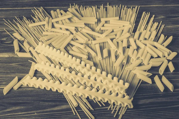Ahşap arka planda farklı türde makarna.