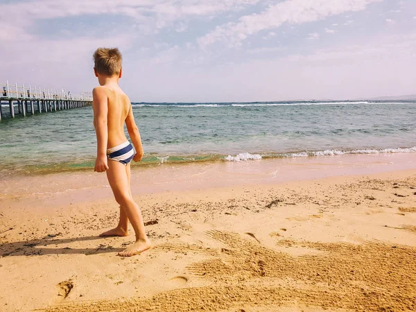 Pieni poika rannalla — kuvapankkivalokuva