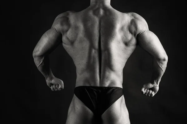 Culturista mostrando i muscoli della schiena e del bicipite, fitnes personali — Foto Stock