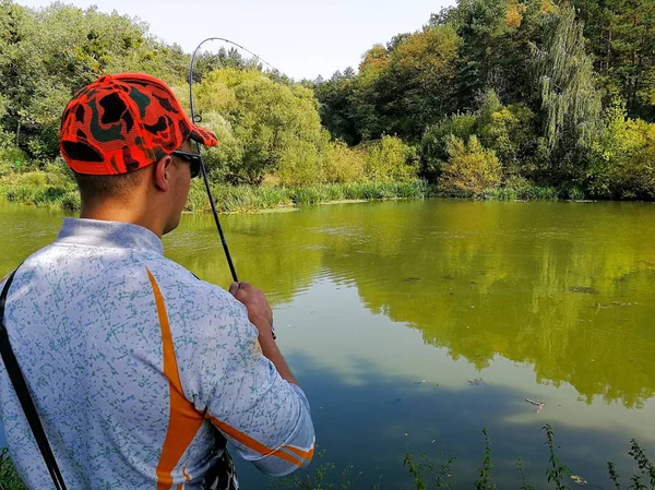 The fisherman is fishing on the lake in summer — Stock Photo, Image