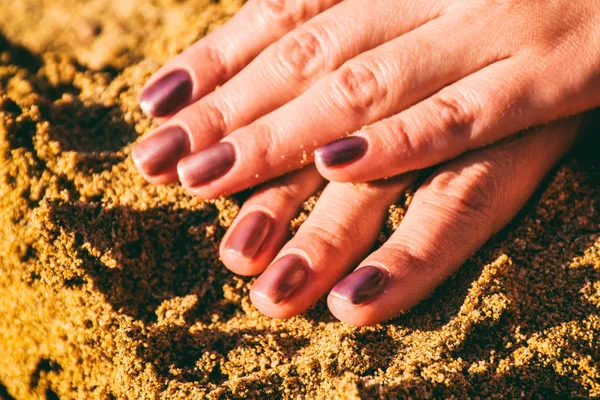 砂の上にマニキュアと手 — ストック写真