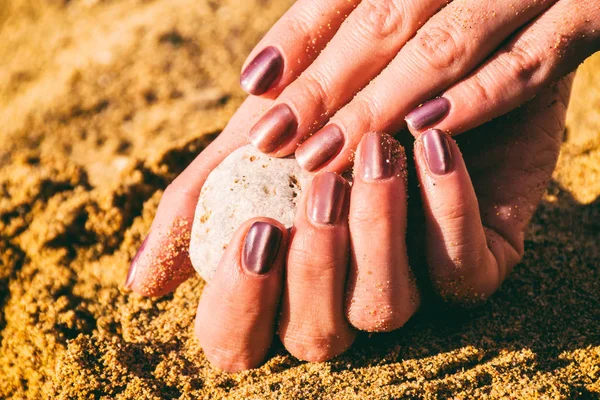 painted nails in the sand
